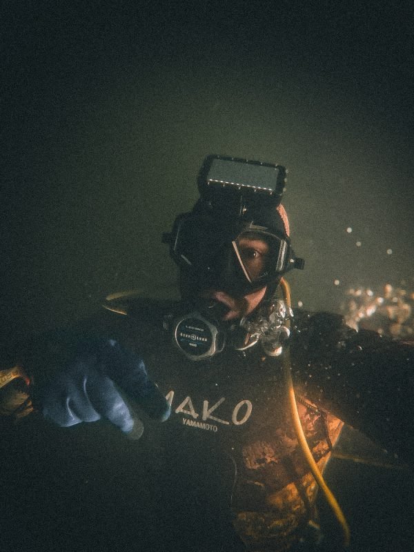 Professional diver performing underwater boat maintenance with commercial diving equipment